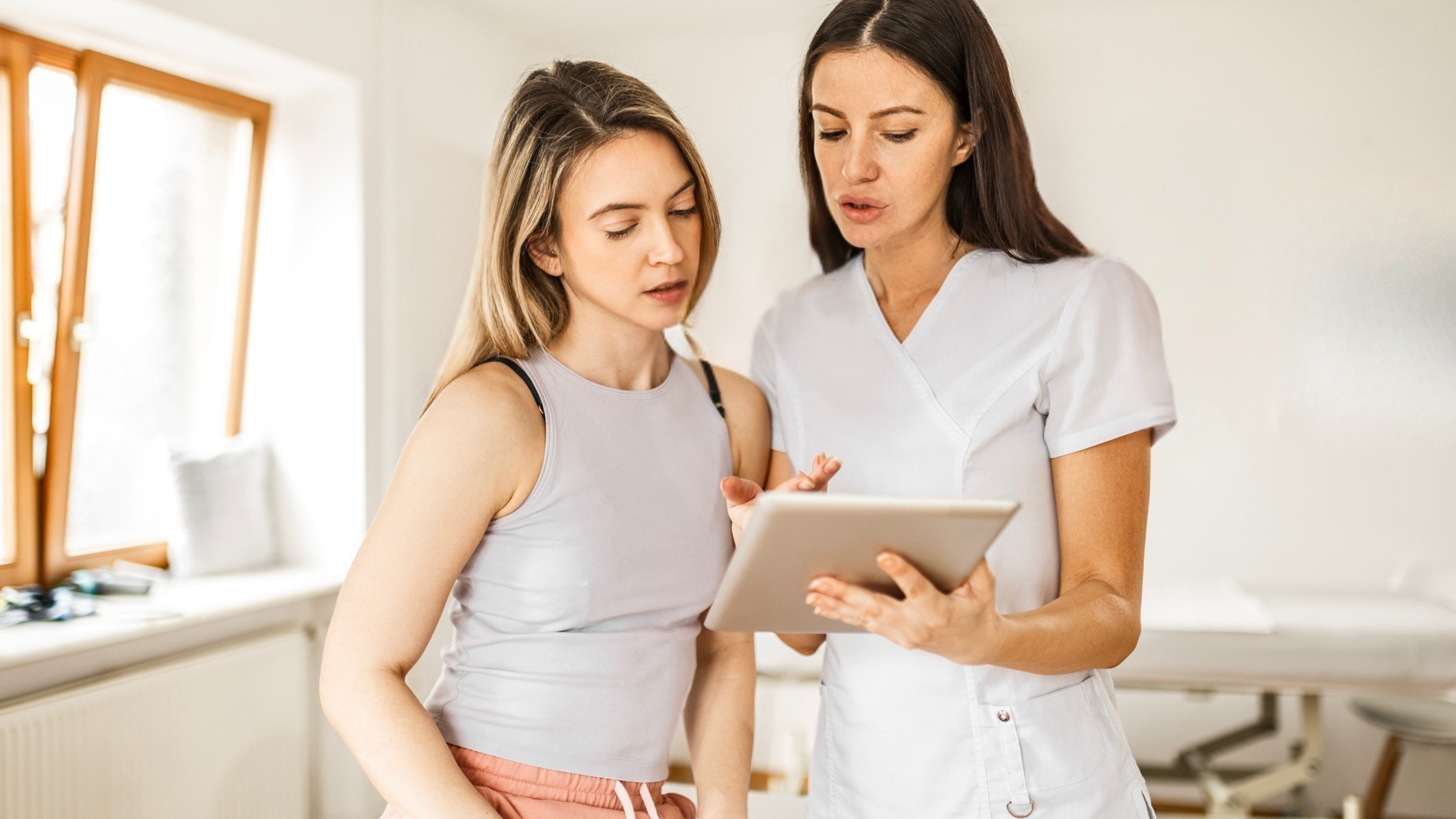 Medspa provider reviewing monthly payment plan options with a patient on a tablet