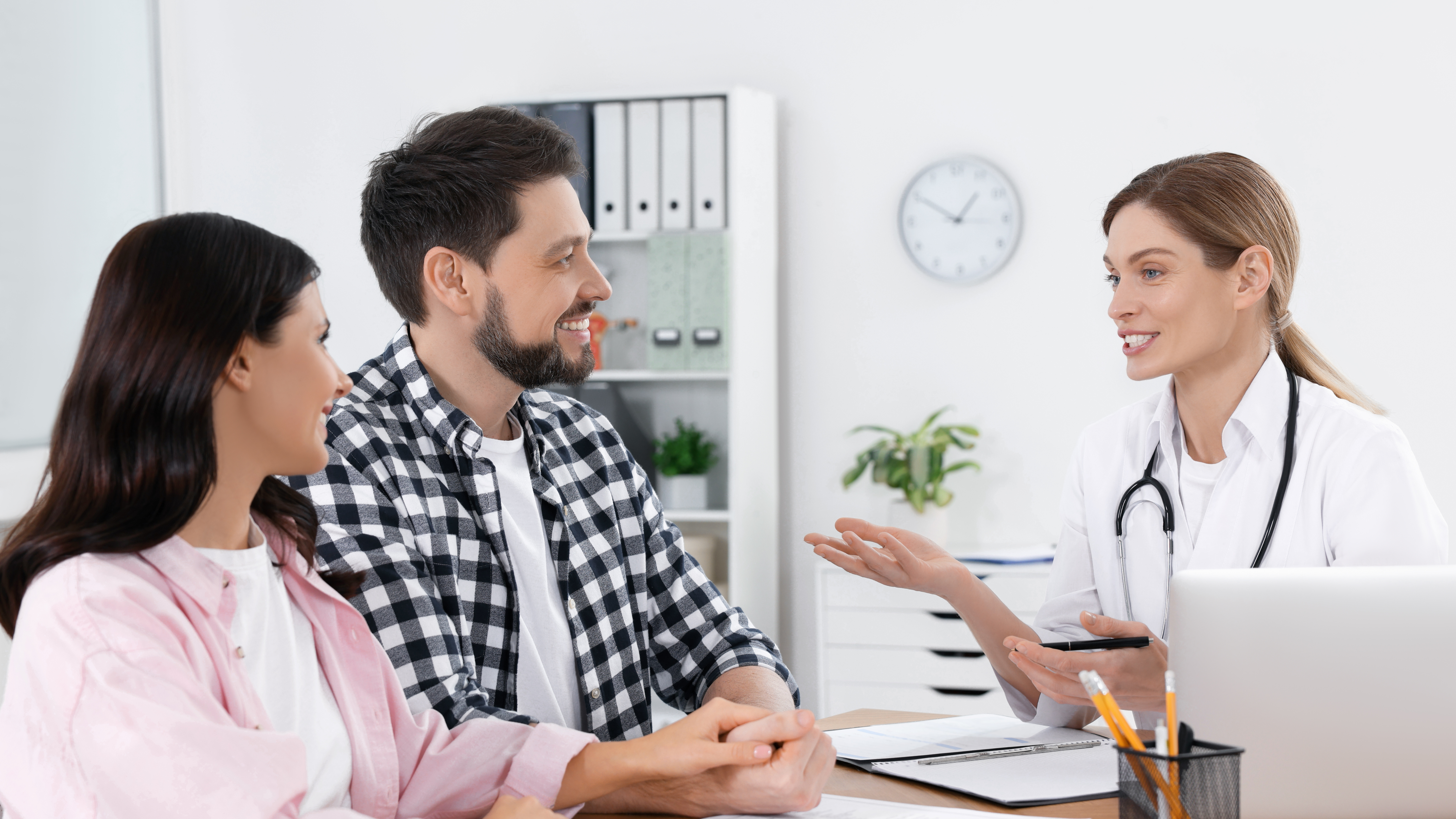 Fertility specialist meeting with prospective parents to discuss care and payment options, illustrating how financing impacts patient decision-making.